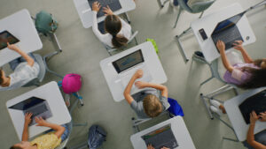 top down view showing a classroom of children on laptops