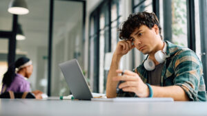 a university student looking at a laptop