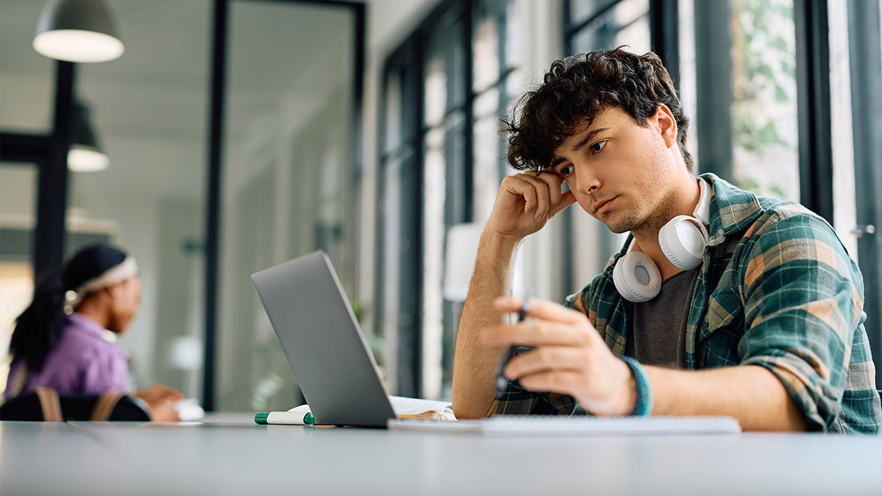 a university student looking at a laptop