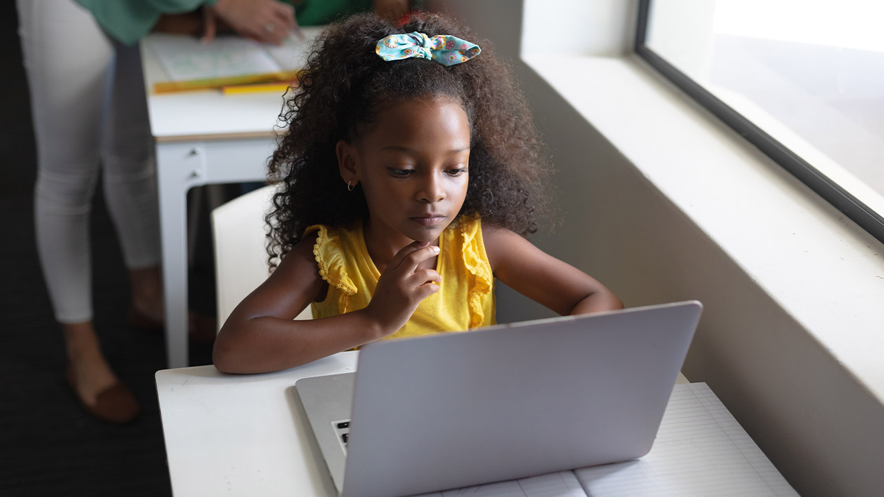 young girl on a laptop in a classroom