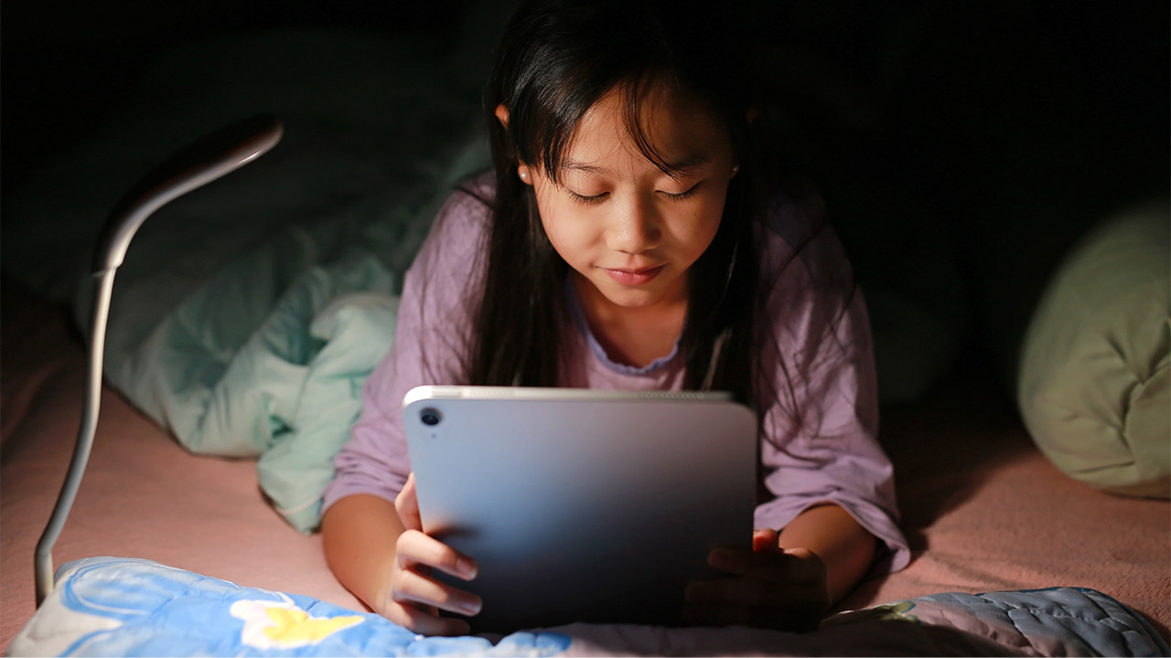 a girl using a tablet screen at night