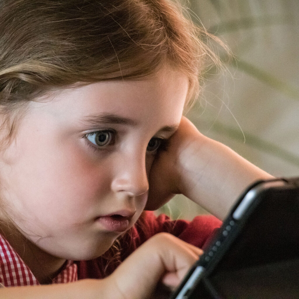 a child staring at a tablet screen